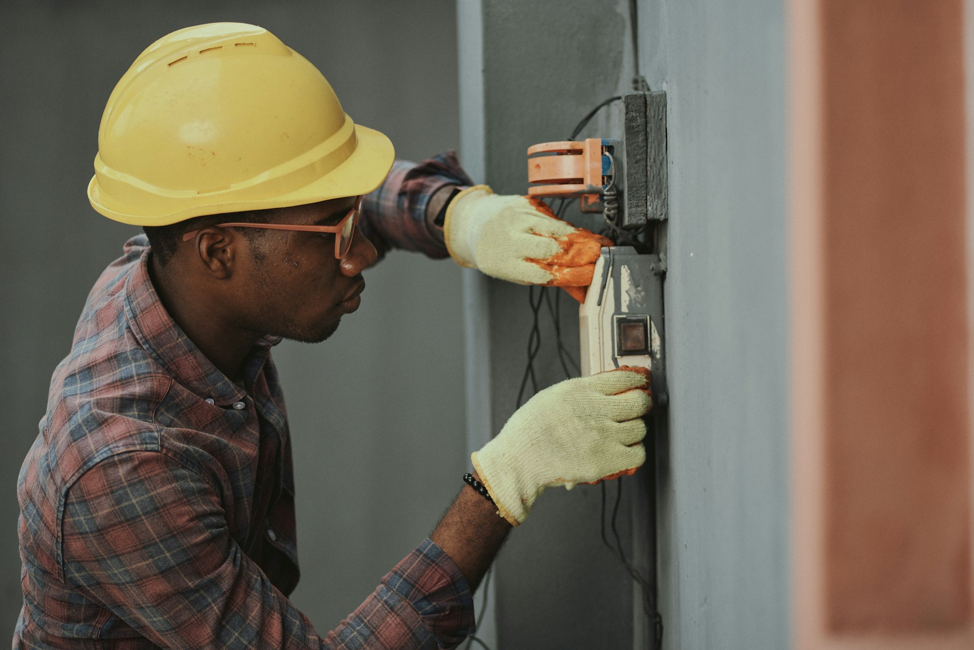 homme au chapeau marron tenant un outil électrique noir et gris